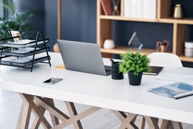 Aufnahme eines Laptops und verschiedener anderer Gegenstände auf einem Arbeitstisch in einem modernen Büro